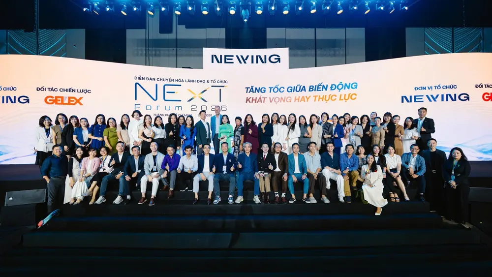 Delegates posing for a group photo in front of the NExT Forum 2026 stage backdrop at THISKYHALL Sala, Ho Chi Minh City