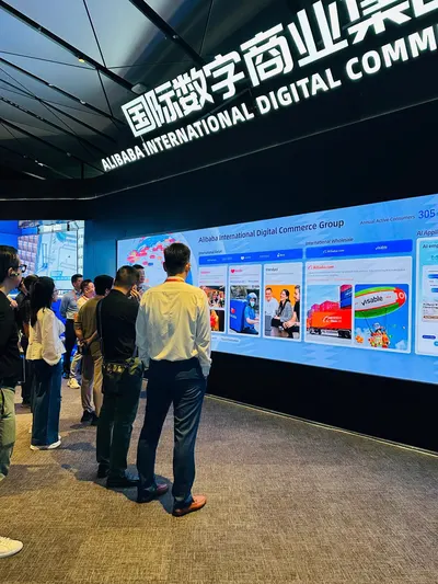 Screen reading “Alibaba International Digital Commerce Group” during the study tour, with delegates standing by